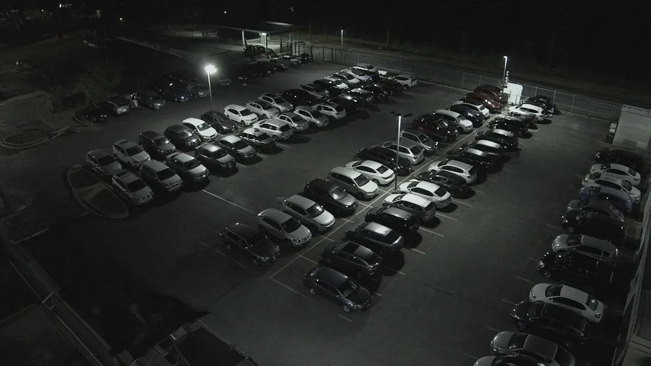 Auto dealership security monitoring CCTV view of a vehicle lot at night for remote video monitoring and live security camera monitoring