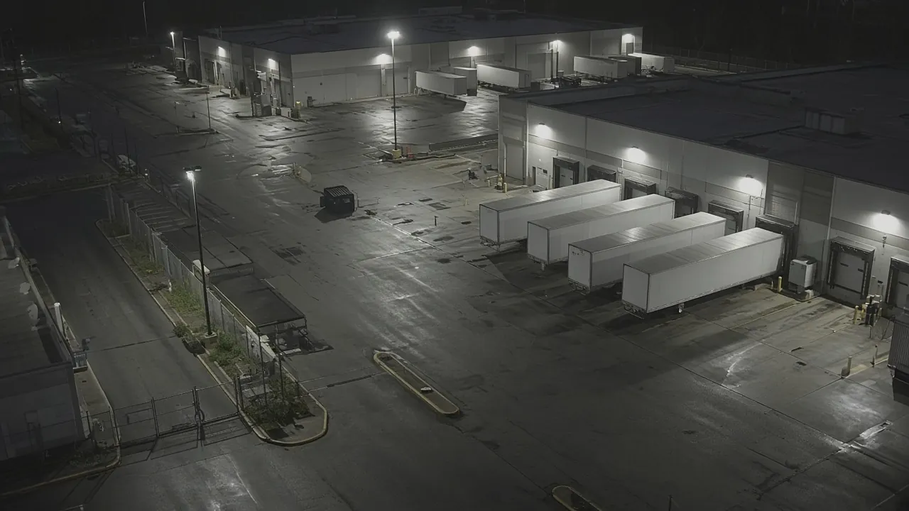 Facility security camera monitoring CCTV view of a commercial building exterior at night for remote video monitoring and live security camera monitoring